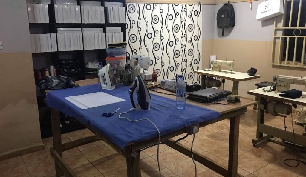 image of a workstation with sewing machines, cutting tables and electric iron