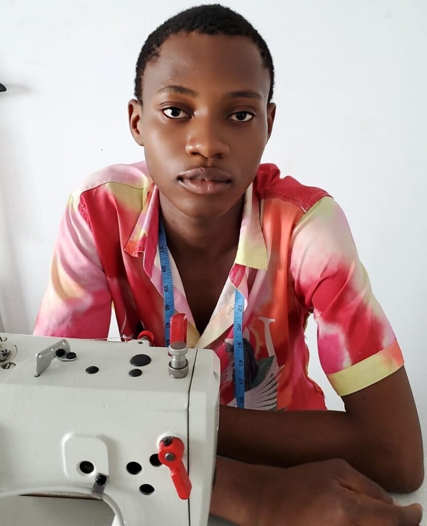 Image of a tailoring trainee in workshop seating in front of a sewing machine